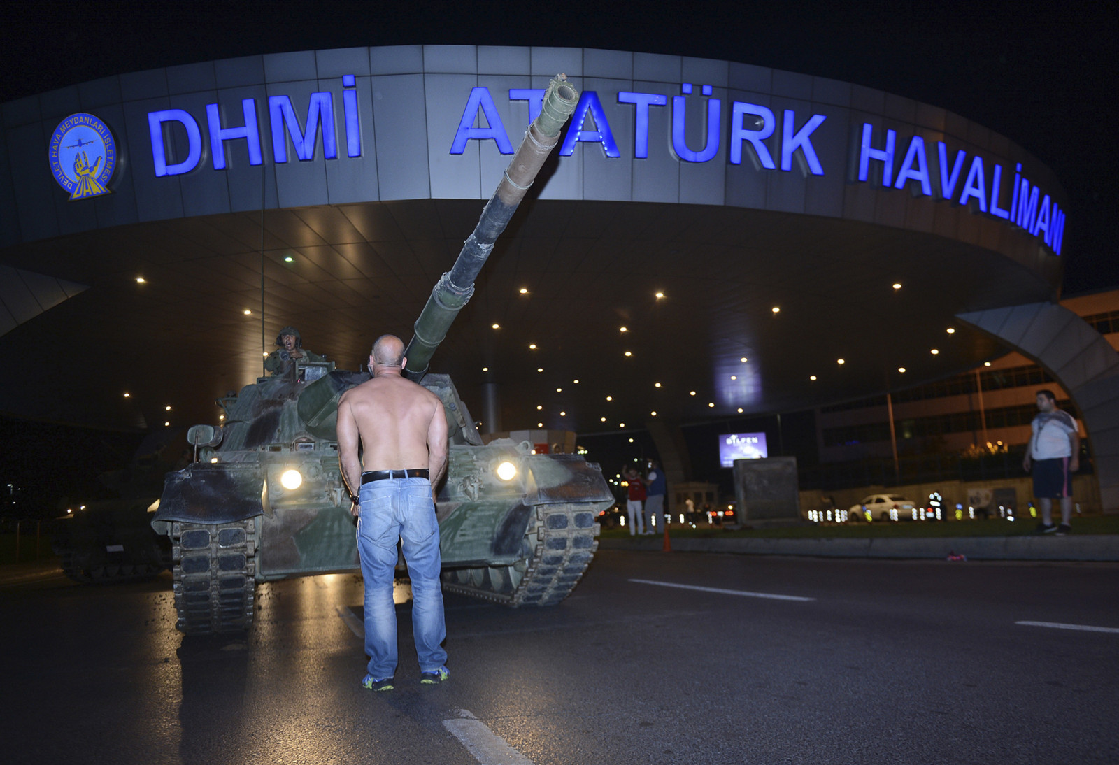 אזרח עומד מול טנק בכניסה לנמל התעופה אטאטורק באיסטנבול. צילום: סוכנות AP
