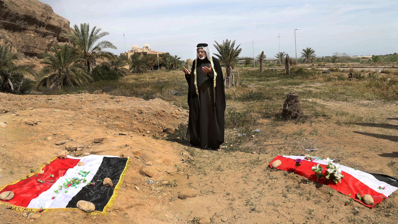 אדם מתאבל על קבר אחים בו קבורים כנראה אזרחים שהיו בעבר חיילים בצבא עיראק ונטבחו ע"י דאעש. יוני 2015. (צילום:סוכנות AP).