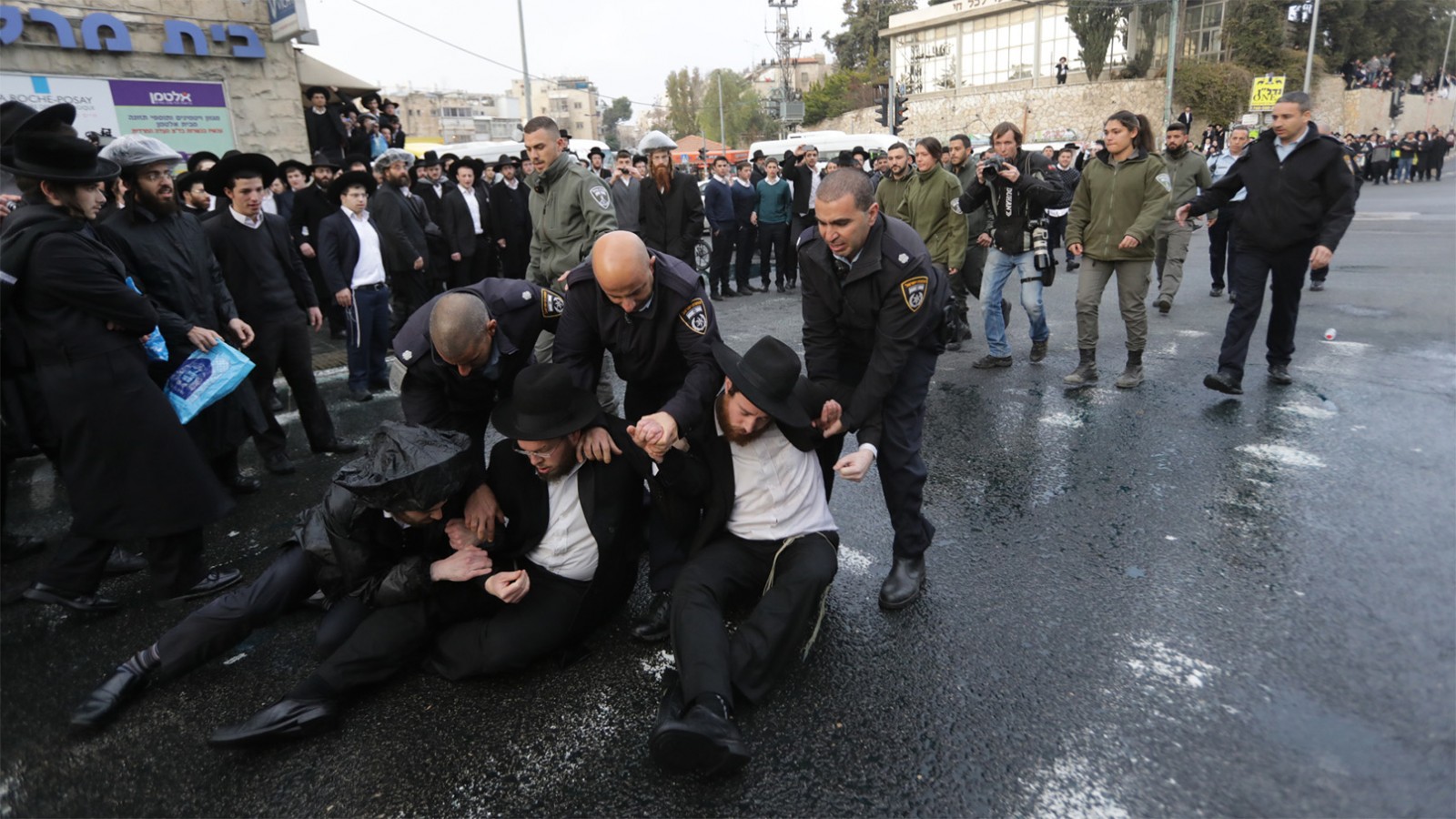 שוטרים עוצרים מפגינים חרדים בשכונת מאה שערים בירושלים (צילום: יונתן זינדל/ פלאש 90).