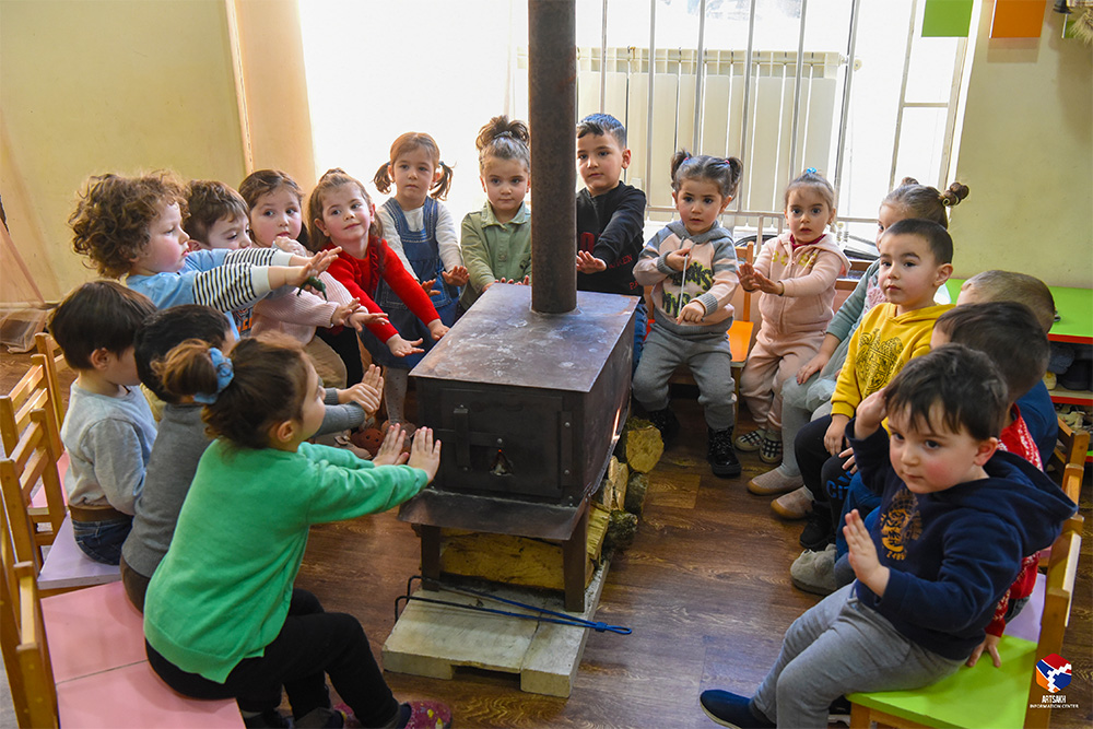 Children in Stepanakert warm up around a heater after the gas supply was cut off. Temperatures are below freezing in the winter and there are no other means to keep warm (Photo: Artsakh Information Center).